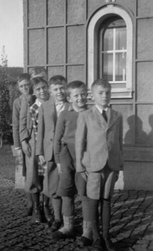 Čtyři chlapci a dívka ve věku od 10 do 12 let jsou seřazeni jako stupínky. V pozadí je vidět roh Richterova domu.